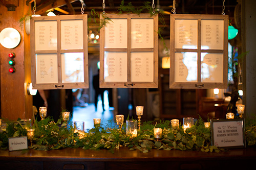 Tableros para asignar las mesas a los invitados con decoración de velas